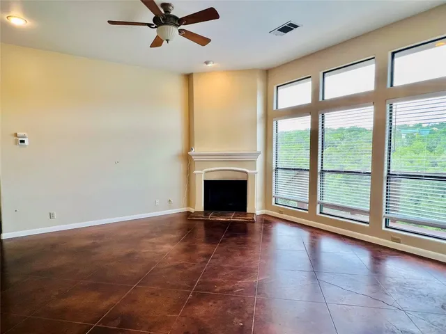 a view of an empty room with a fireplace and a window