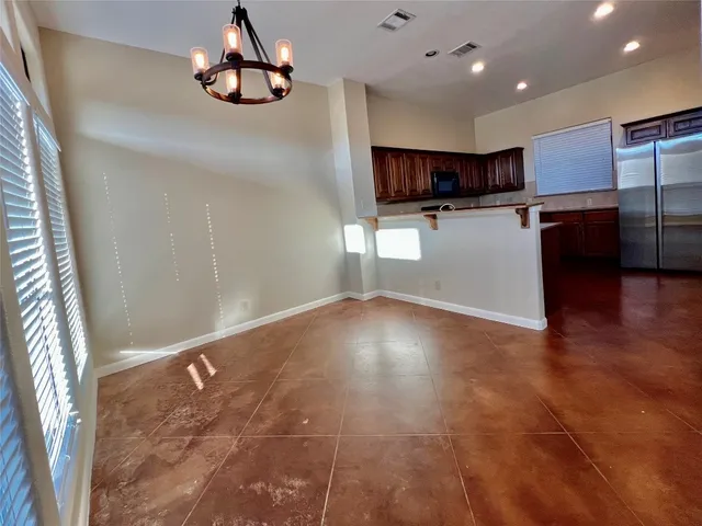 a view of kitchen with stainless steel appliances granite countertop a refrigerator and a stove top oven