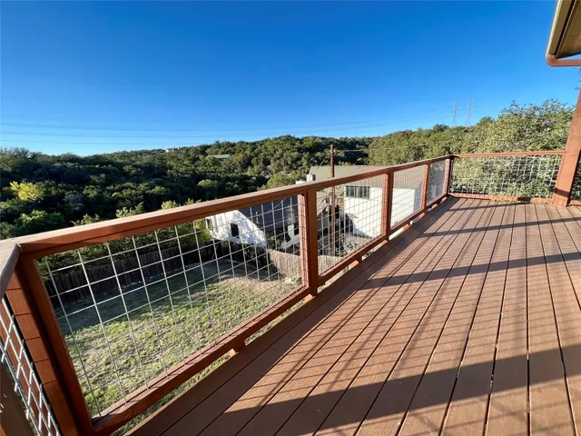 a view of balcony with wooden floor and fence