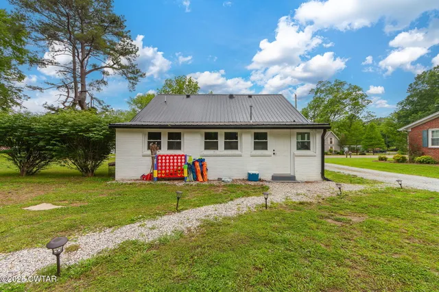 a front view of a house with a yard porch and outdoor seating