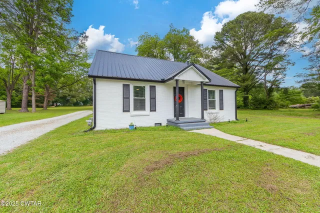 a front view of a house with a garden and yard