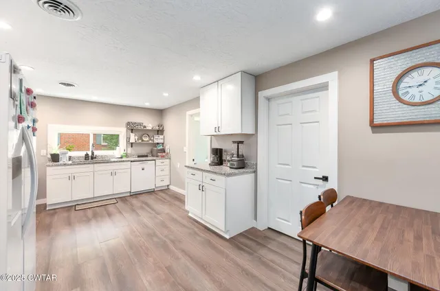 a kitchen with a sink cabinets and wooden floor