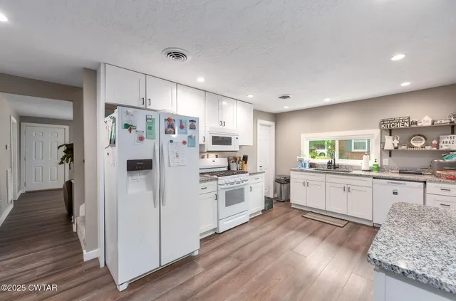 a kitchen with white cabinets and stainless steel appliances