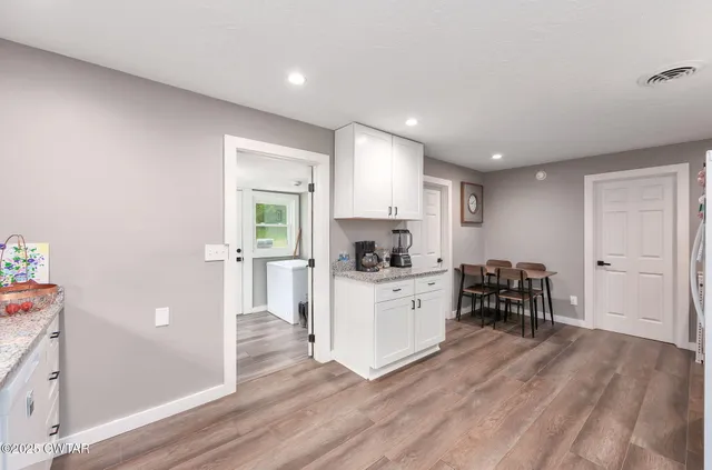 a kitchen with furniture and wooden floor