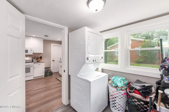 a kitchen that has a lot of white cabinets and wooden floor