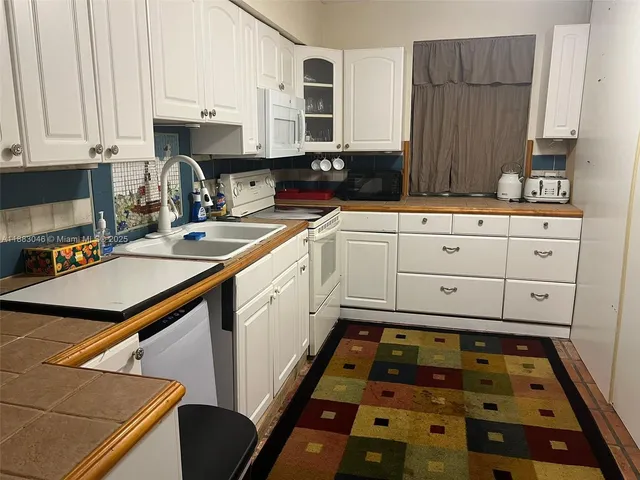 a kitchen with sink a stove and cabinets