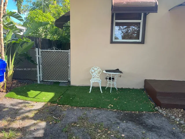 a white bench sitting in the backyard of a house
