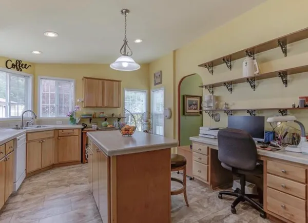 a kitchen that has a lot of cabinets in it and wooden floors