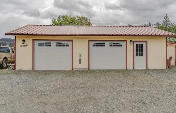 a view of a white house with a yard