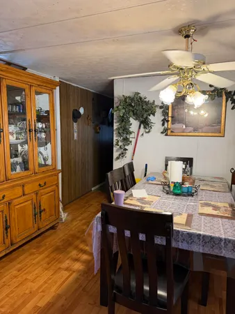 a living room with stainless steel appliances kitchen island granite countertop a sink and wooden floor