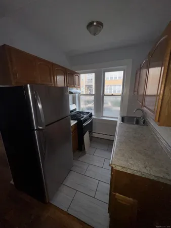 a kitchen with granite countertop a refrigerator a stove a sink and dishwasher