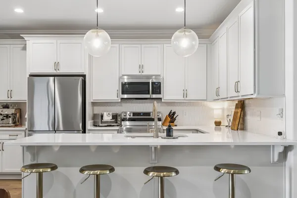 a kitchen with appliances a center island and cabinets