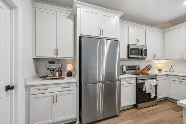 a kitchen with white cabinets and stainless steel appliances