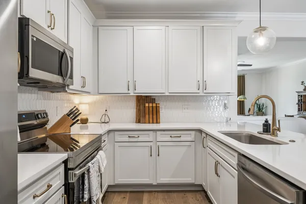 a kitchen with stainless steel appliances granite countertop a sink stove and microwave