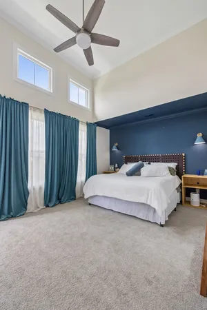 a spacious bedroom with a bed and a chandelier