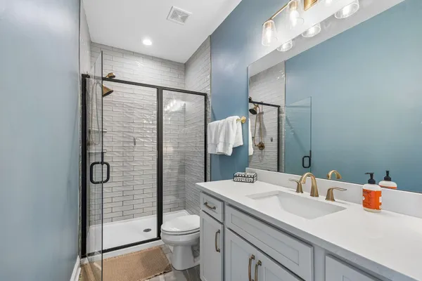 a bathroom with a sink a toilet and shower