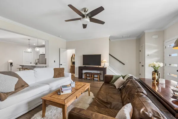 a living room with furniture and a flat screen tv with wooden floor