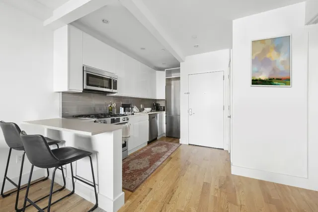 a kitchen with granite countertop a refrigerator stove and microwave