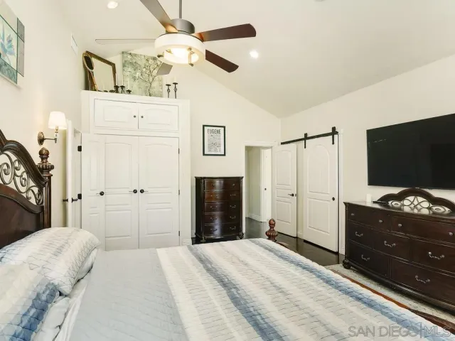a bedroom with a bed and a flat tv screen on dresser
