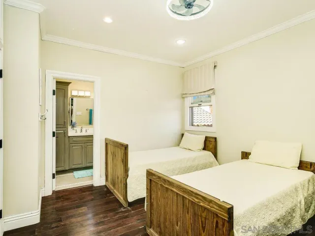 a bedroom with two beds and a refrigerator