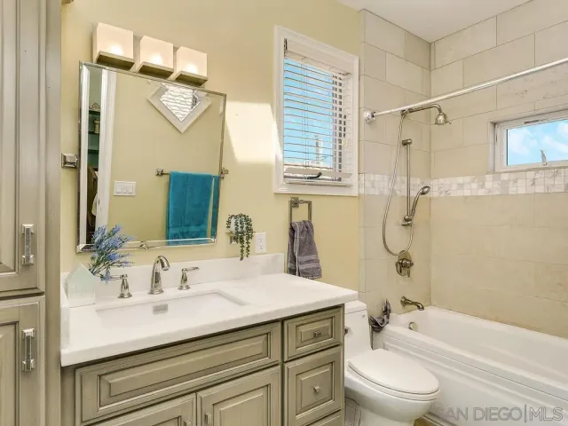 a bathroom with a sink a toilet a mirror and shower