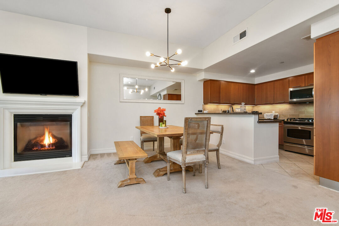 15248 Clark Street, Unit 104 Sherman Oaks, CA 91411 - Photo 13 of 48 a living room with furniture a fireplace and a flat screen tv