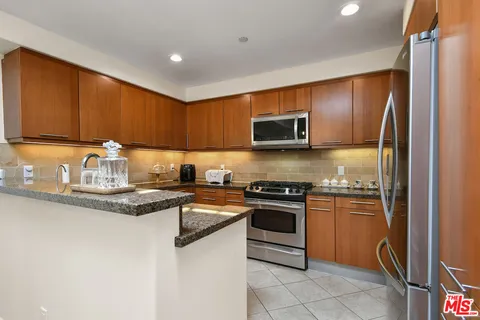 a kitchen with stainless steel appliances granite countertop a stove top oven a sink and dishwasher