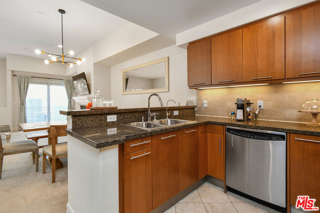 15248 Clark Street, Unit 104 Sherman Oaks, CA 91411 - Photo 18 of 48 a kitchen with stainless steel appliances granite countertop a sink a stove cabinets and a dining table