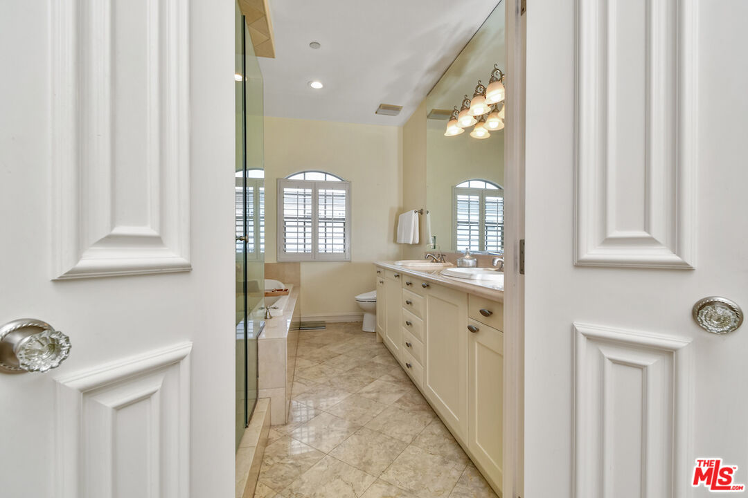 15248 Clark Street, Unit 104 Sherman Oaks, CA 91411 - Photo 40 of 48 a bathroom with a double vanity sink and mirror with shower