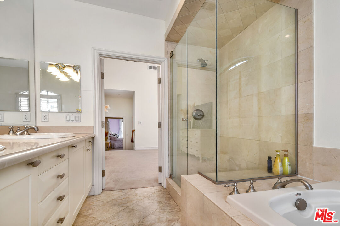 15248 Clark Street, Unit 104 Sherman Oaks, CA 91411 - Photo 43 of 48 a bathroom with a tub sink mirror and shower