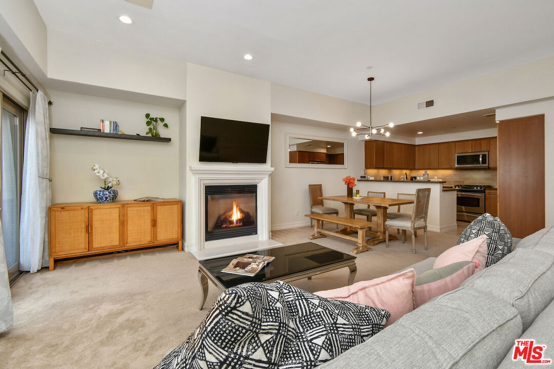 15248 Clark Street, Unit 104 Sherman Oaks, CA 91411 - Photo 10 of 48 a living room with furniture a fireplace and a flat screen tv