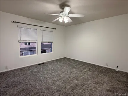 an empty room with a window and a ceiling fan
