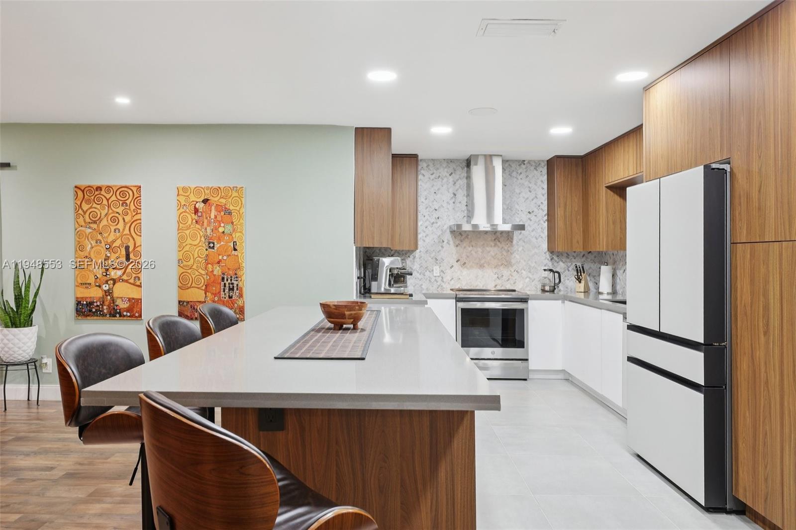 5301 Pierce Street Hollywood, FL 33021 - Photo 16 of 45 a kitchen with a refrigerator a stove a sink and white cabinets with wooden floor