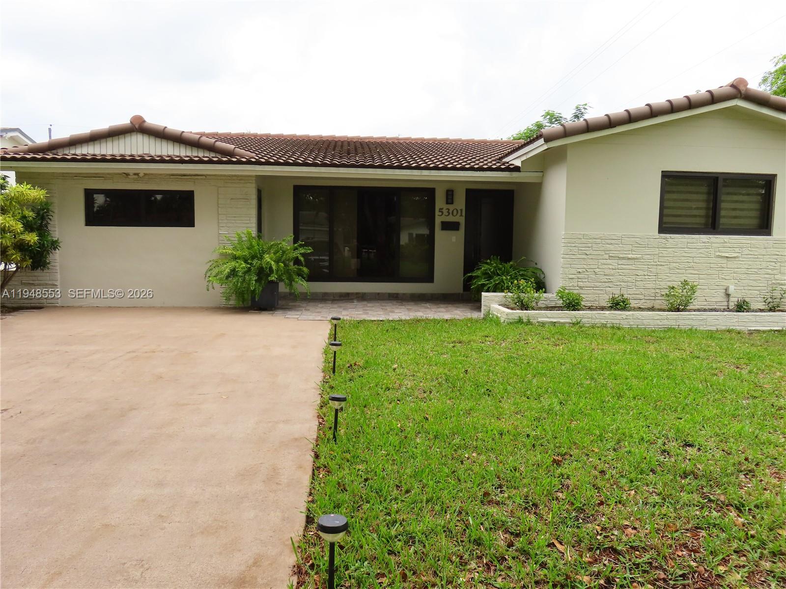 5301 Pierce Street Hollywood, FL 33021 - Photo 2 of 45 a front view of a house with a yard and garage