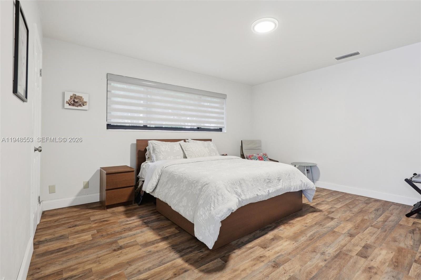 5301 Pierce Street Hollywood, FL 33021 - Photo 26 of 45 a bedroom with a bed and wooden floor