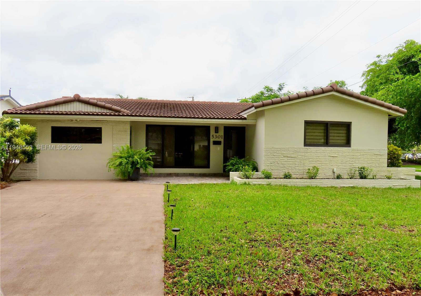 5301 Pierce Street Hollywood, FL 33021 - Photo 3 of 45 a front view of house with yard and green space