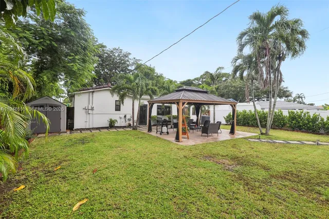 a view of a house with backyard and sitting area