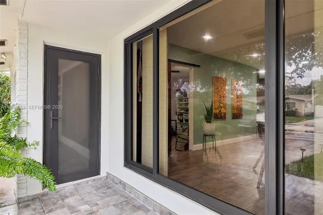 a view of a hallway with wooden floor and a glass door