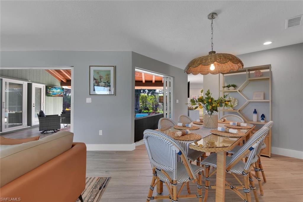 2328 Clipper Way Naples, FL 34104 - Photo 16 of 44 a dining room with furniture a potted plant and a chandelier