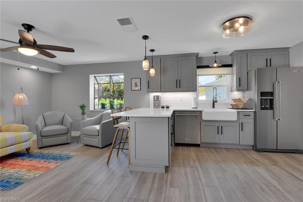 2328 Clipper Way Naples, FL 34104 - Photo 19 of 44 a kitchen with a wooden floor window and stainless steel appliances