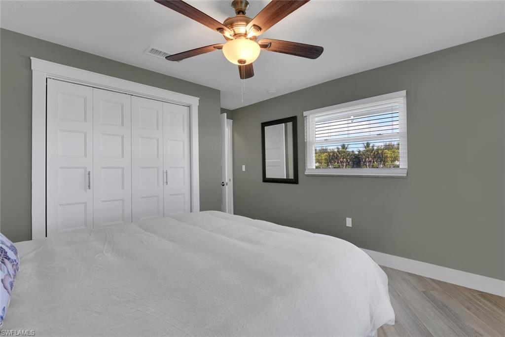 2328 Clipper Way Naples, FL 34104 - Photo 31 of 44 a bedroom with a large bed and a chandelier