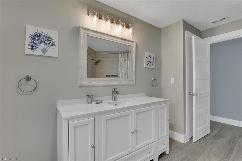 2328 Clipper Way Naples, FL 34104 - Photo 33 of 44 a bathroom with a double vanity sink and a mirror