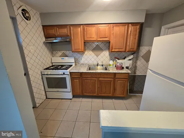 a kitchen with a stove top oven cabinets and a refrigerator