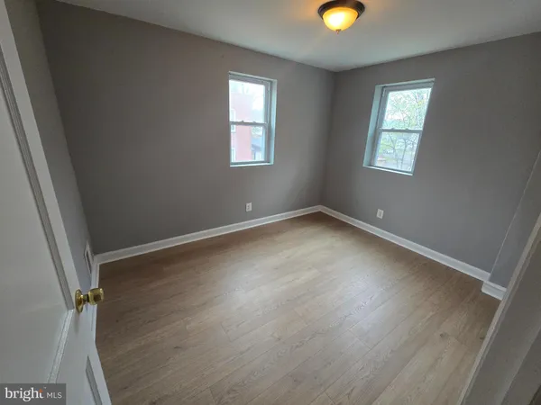 a view of an empty room with window and closet area