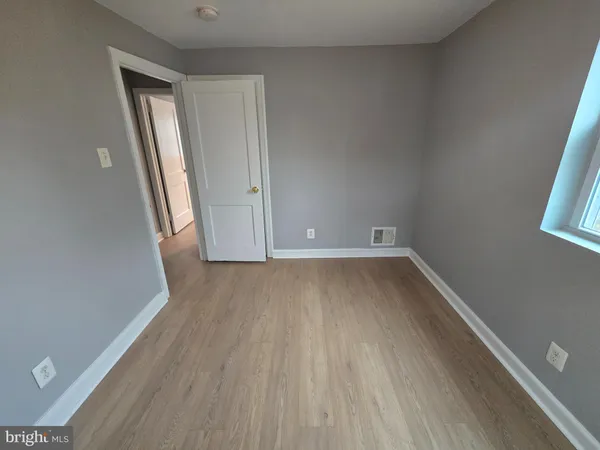 an empty room with wooden floor and closet