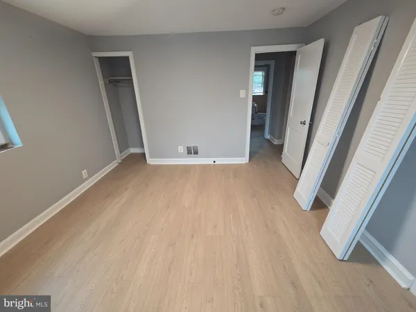 an empty room with wooden floor and entrance