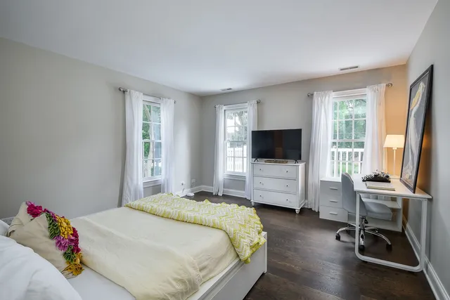 a view of a white house with a yard chairs and table in a patio