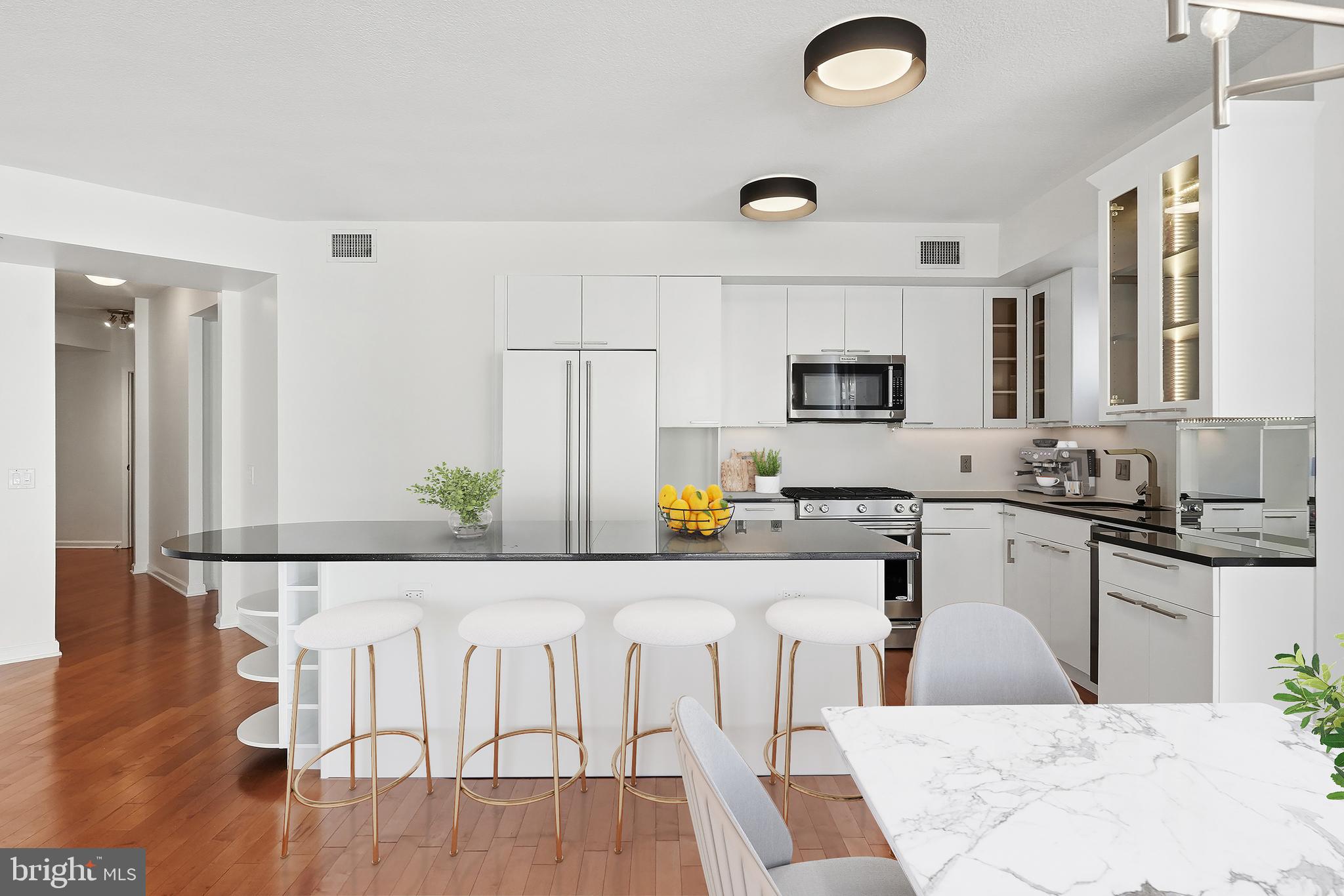 440 L Street Northwest, Unit 805 Washington, DC 20001 - Photo 10 of 38 a kitchen with granite countertop a stove top oven a sink a dining table and chairs