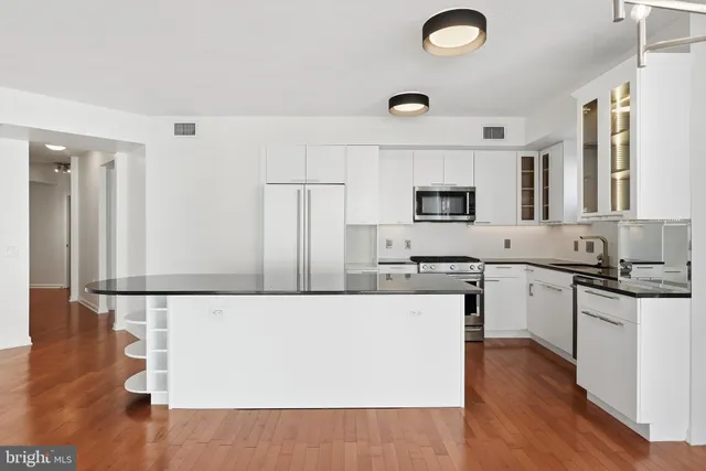 a kitchen with granite countertop a stove top oven a sink a dining table and chairs