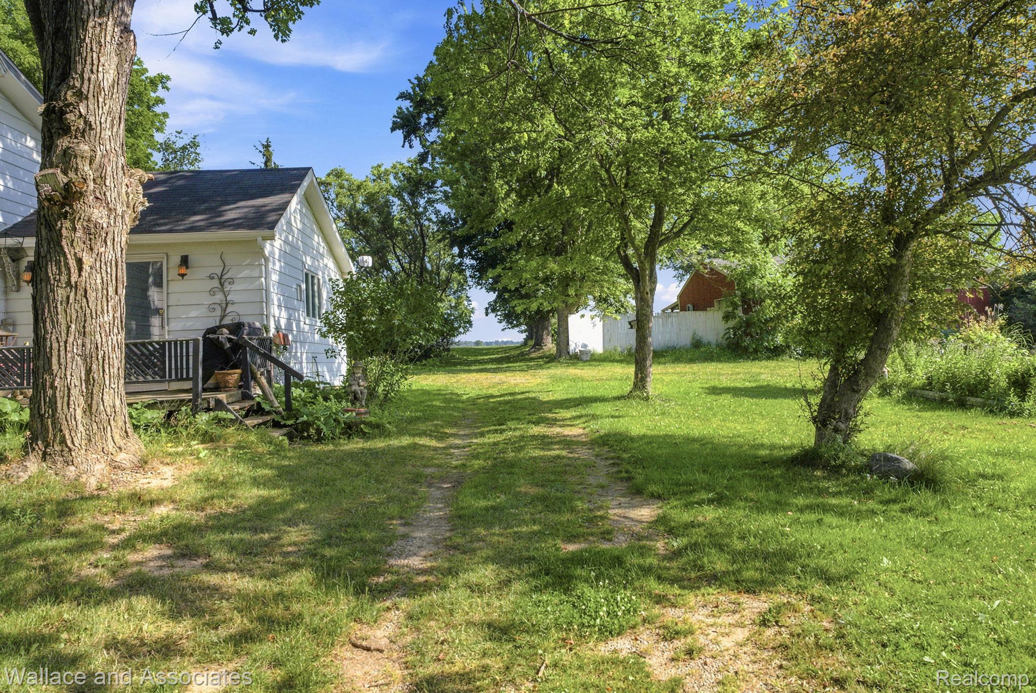 5949 Roach Road Croswell, MI 48422 - Photo 39 of 48 Expansive grassy yard with mature trees and a gravel path